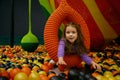 Smiling baby girl swinging on hanging ball playing in balls pool Royalty Free Stock Photo