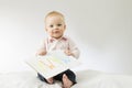 Smiling baby looking at camera. Cute infant kid holding sign Mama on big postcard