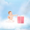 Smiling baby with present on the cloud Royalty Free Stock Photo