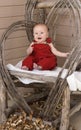 Smiling Baby in Red Overalls