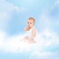 Smiling baby sitting on the cloud Royalty Free Stock Photo