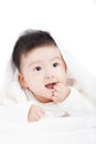 Smiling baby sucking finger under blanket or towel Royalty Free Stock Photo