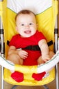 Smiling baby in a yellow baby carriage