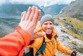 Smiling backpacker dressed orange jacket giving High Five to female mate during Himalaya valley trekking. Mera peak climbing route Royalty Free Stock Photo