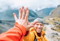 Smiling backpacker dressed orange jacket giving High Five to female mate during Himalaya valley trekking. Mera peak climbing route Royalty Free Stock Photo