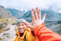 Smiling backpacker dressed orange jacket giving High Five to female mate during Himalaya valley trekking. Mera peak climbing route Royalty Free Stock Photo
