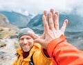 Smiling backpacker dressed orange jacket giving High Five to female mate during Himalaya valley trekking. Mera peak climbing route Royalty Free Stock Photo