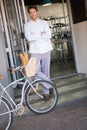 Smiling baker with arms crossed and bike