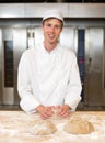 Smiling baker kneading dough in bakery Royalty Free Stock Photo