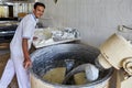 Smiling baker kneads bread dough in kneading machine, Kashan, Ir