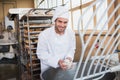 Smiling baker preparing dough in industrial mixer