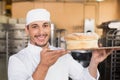 Smiling baker showing loaf of bread Royalty Free Stock Photo