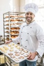 Smiling baker with tray of uncooked dough