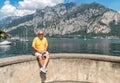 Smiling Bald mature man sitting on the shore of Como lake.