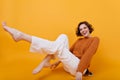 Smiling barefooted girl with eacstatic face expression posing with legs up. Laughing female model in woolen sweater