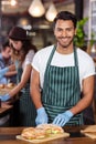 Smiling barista cutting sandwich