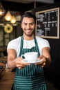 Smiling barista holding coffee Royalty Free Stock Photo