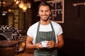 Smiling barista holding coffee Royalty Free Stock Photo