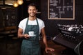 Smiling barista holding a cup of coffee Royalty Free Stock Photo