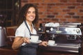 Smiling barista holding two cups of coffee