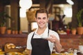 Smiling barista offering cup of coffee to camera Royalty Free Stock Photo