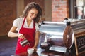 Smiling barista pouring milk in a cup