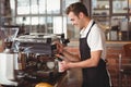 Smiling barista steaming milk at coffee machine Royalty Free Stock Photo