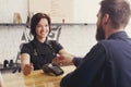 Smiling barista taking payment from client at cafe Royalty Free Stock Photo