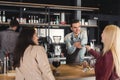 Smiling barista taking payment from clients Royalty Free Stock Photo