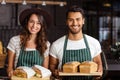 Smiling baristas holding bread and sandwiches Royalty Free Stock Photo