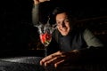 Smiling barman holding an elegant cocktail glass with splashing Royalty Free Stock Photo