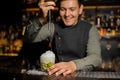 Smiling barman pouring sweet syrup into the mojito Royalty Free Stock Photo