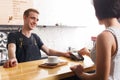 Smiling barman taking payment from client at counter of a coffee shop Royalty Free Stock Photo