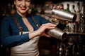 Smiling bartender girl holding two steel cocktail shakers Royalty Free Stock Photo