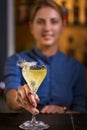 Smiling bartender girl offers yellow cocktail into glass at the bar Royalty Free Stock Photo