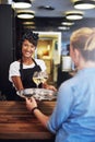 Smiling bartender serving glasses of white wine