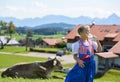 Smiling Bavarian boy drink milk on the meadow with cow . Alps i Royalty Free Stock Photo