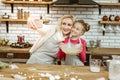 Smiling beaming lady making photo of herself with positive daughter