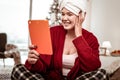 Smiling beaming woman being contented with information on tablet