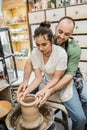 Smiling bearded artisan shaping clay vase