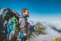 Smiling bearded climber with huge backpack with climbing rope and sleeping bag enjoying a Fren Apls valley with picturesque clouds Royalty Free Stock Photo