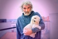 Handsome Adult Man holding his liitle white dog maltese.