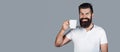 Smiling bearded hipster man holding cup of coffee or tea. Handsome mans holds cup of coffee, tea. Bearded man smiling