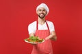 Smiling bearded male chef cook or baker man in striped apron toque chefs hat posing isolated on red background. Cooking Royalty Free Stock Photo