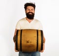 Smiling bearded man with barrel or keg of whiskey, wine or beer. Handsome man with oak barrel or cask of beer. Beer for Royalty Free Stock Photo