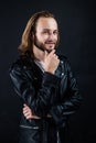 smiling bearded man biker in leather jacket with long hair, punk style Royalty Free Stock Photo