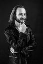 smiling bearded man biker in leather jacket with long hair, punk style Royalty Free Stock Photo