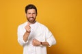 Smiling bearded man doing finger heart on orange background. Space for text Royalty Free Stock Photo