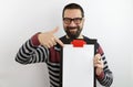 Bearded man with eyeglasses wearing casual clothes holding a clipboard with blank sheet pointing with his finger Royalty Free Stock Photo