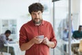 Smiling Bearded Man Holding Smartphone in Office Royalty Free Stock Photo